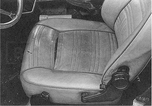 Fig. 3-15. Torn seat seams could be a result of brittleness caused by the car sitting in a hot place. Torn fabric gives opportunity to verify that material is plastic, not leather. Woven fabric backing indicates man-made material.