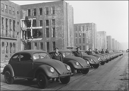 The first type of car that the VW factory could produce after the war was modeled on the high-legged wartime Type 82E, with a Beetle body on a Kubel chassis.  Ivan Hirst is second in this row of British officials with the cars they called the Type 51.