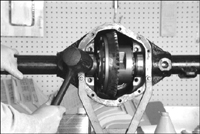 Fig. 5-127 While feeler gauge readings were between the outer edge of bearing cups and the axle housing (with no shims in place), shims install inboard of bearings. Shims provide the correct bearing preloads and gear backlash. Oil bearing cups, and tilt the cups slightly to start installation of the carrier. Tap evenly.