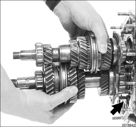 Slide shafts with gears and forks out of differential housing, leaving 1st - 2nd gear selector rod in transmission case.
NOTE-
Check the number and thickness of shims (arrow) between differential housing and bearing flange. This shimmed surface controls the pinion shaft depth. If no repairs are being carried out on the differnetial bearing or the differential, the exact shim pack should be reinstalled.
Manual Transmission–Controls and Case
page 340-20